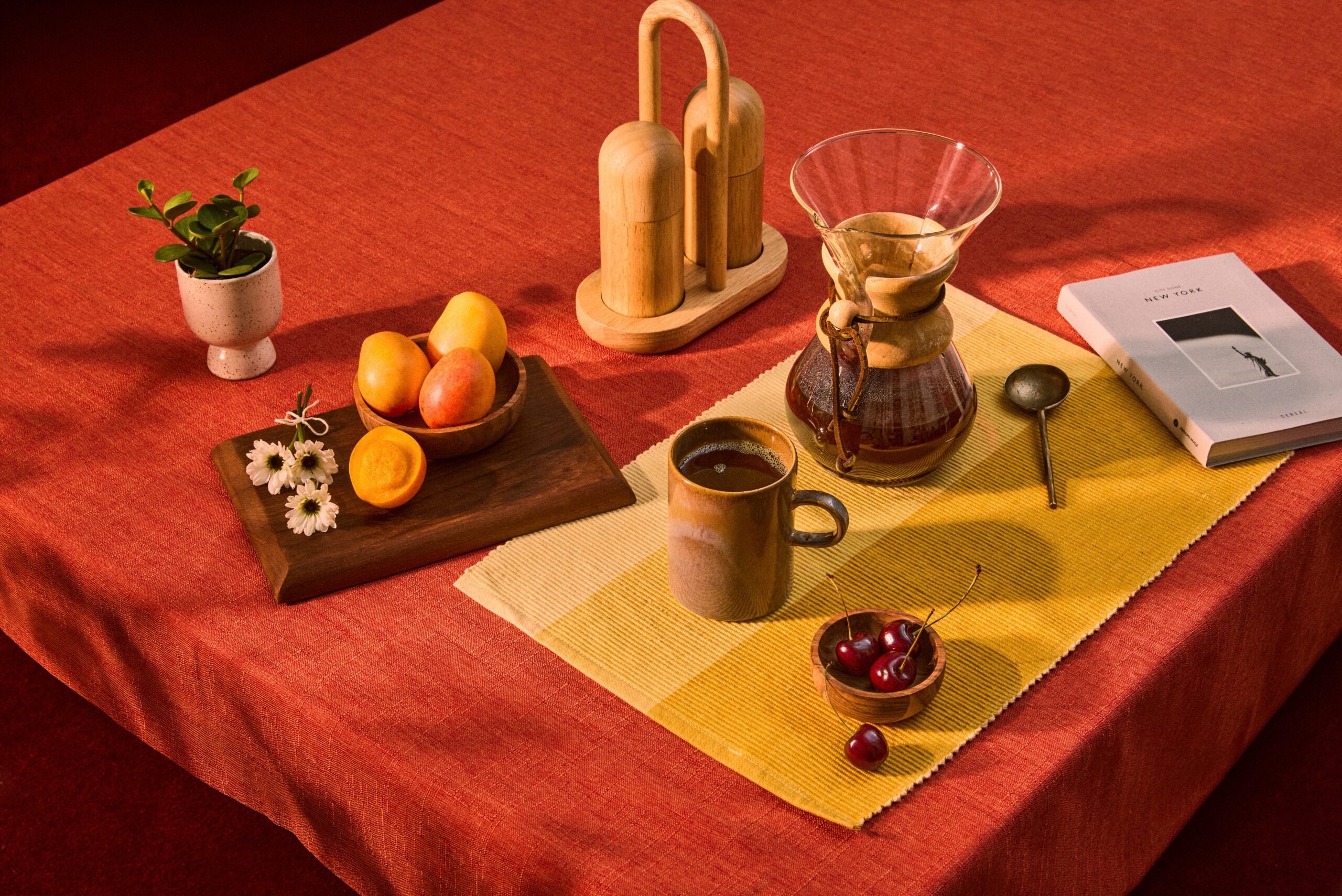 Still life with coffee, fruit, and warm tabletop styling in rich color tones