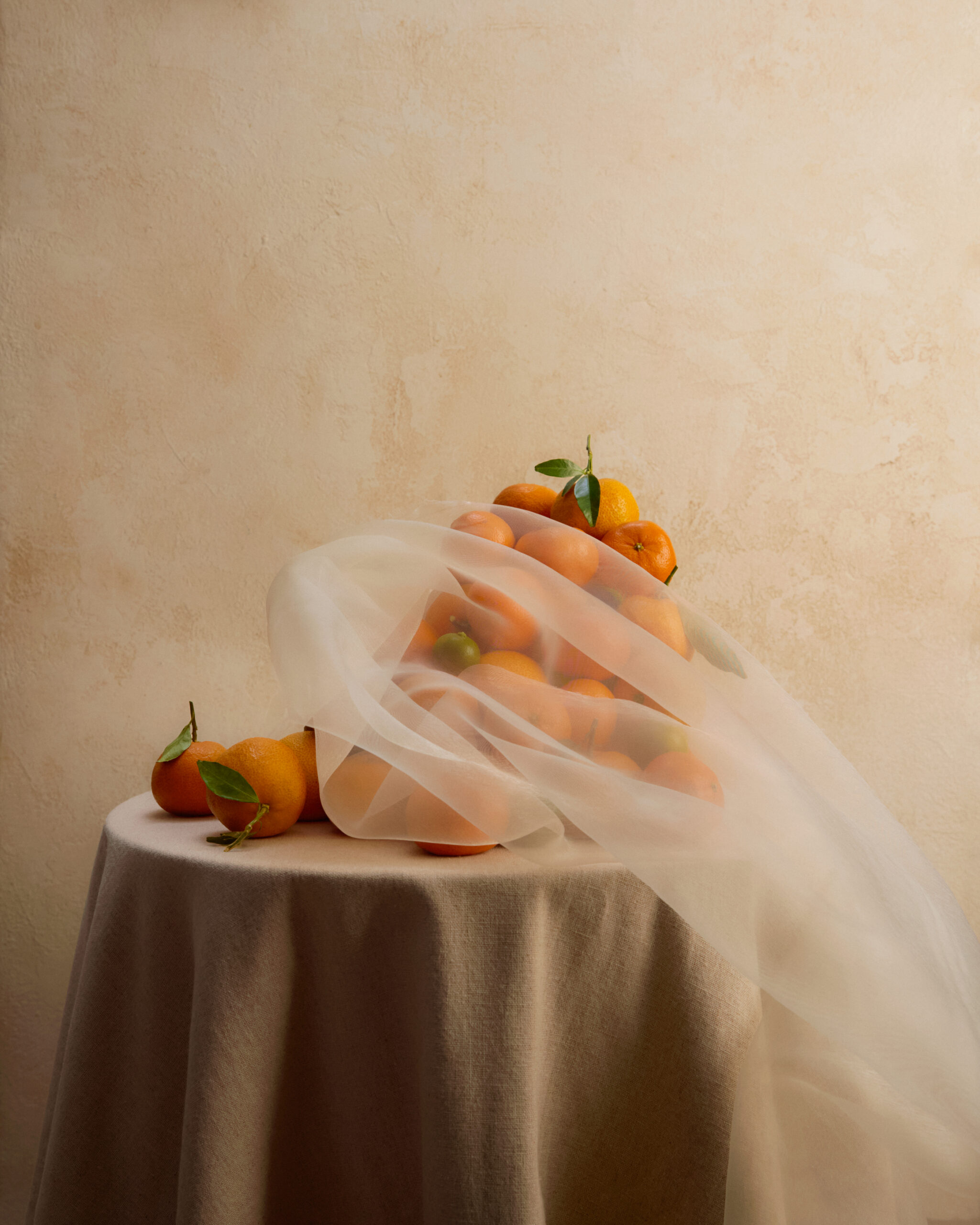 Dessert still life on neutral table with soft fabric drape and styled fruit