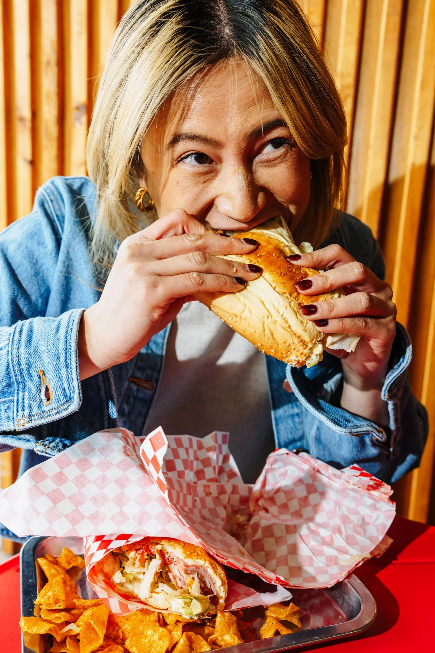 Woman biting into burger, candid food lifestyle moment