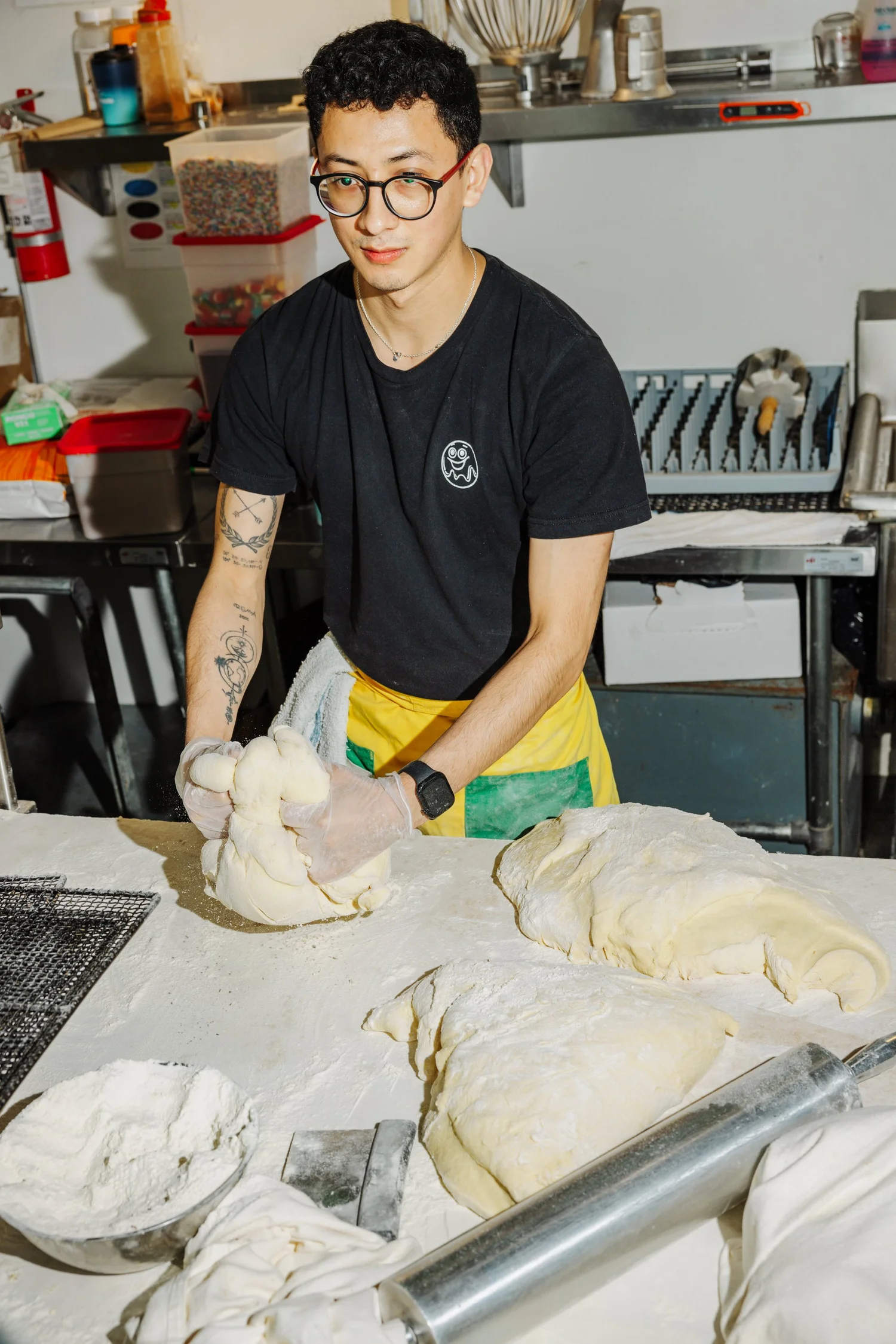 Baker shaping dough on counter, hands-on food preparation
