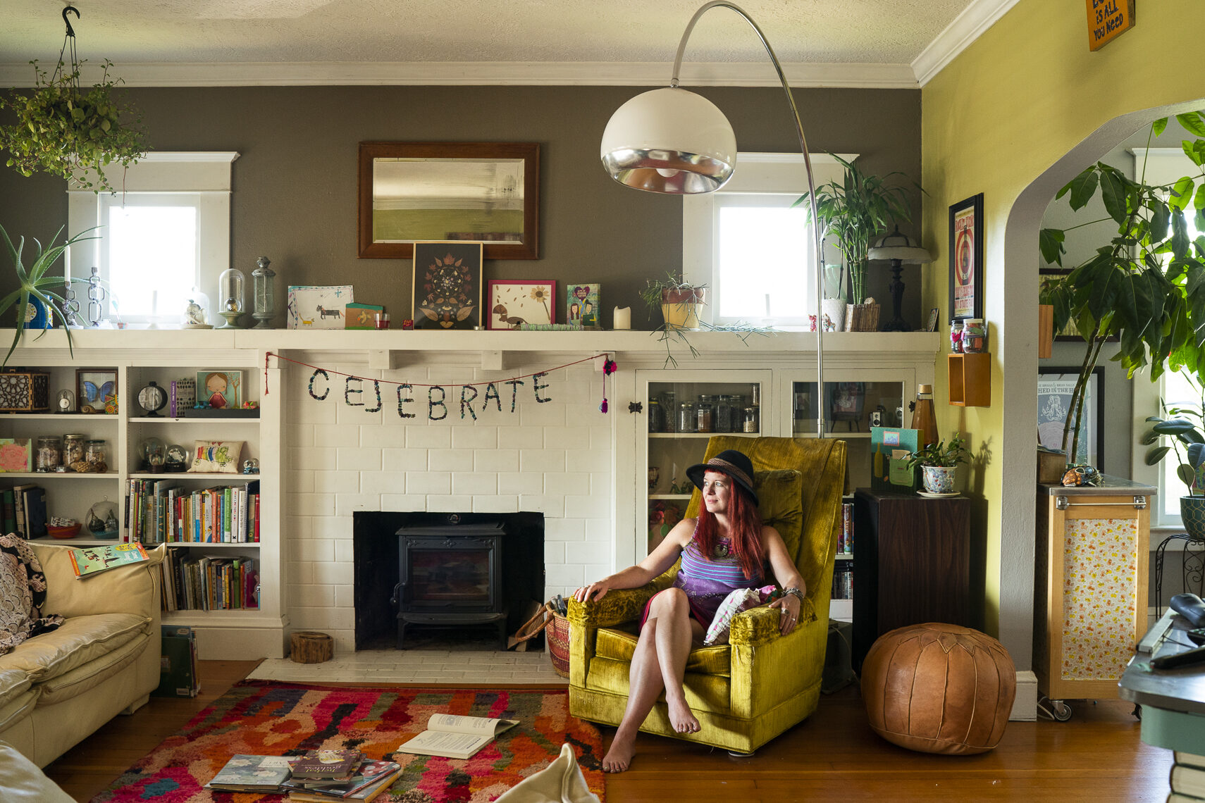 Woman sitting in living room with warm natural light, lifestyle interior portrait
