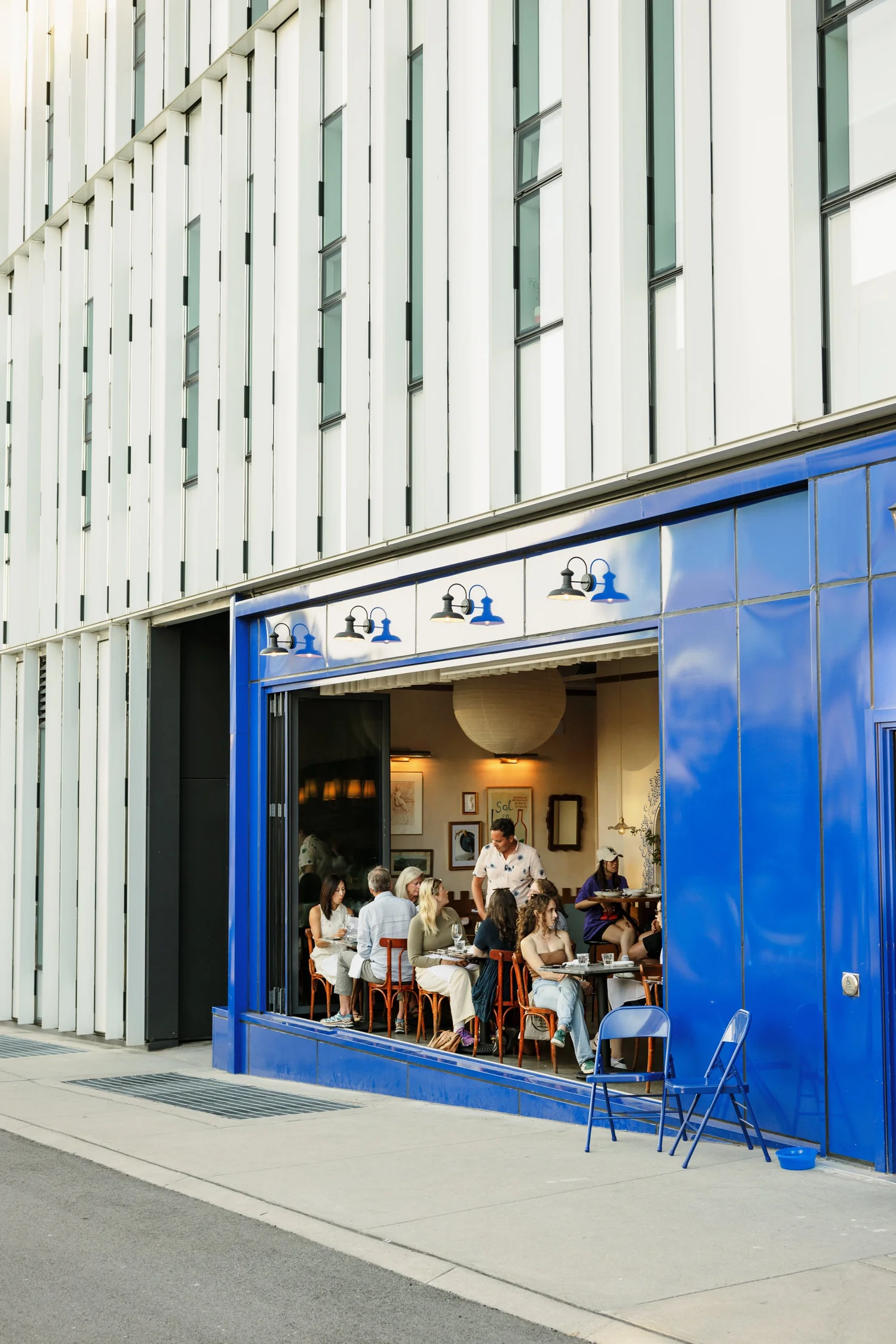 Bright blue storefront with people seated inside near large open windows