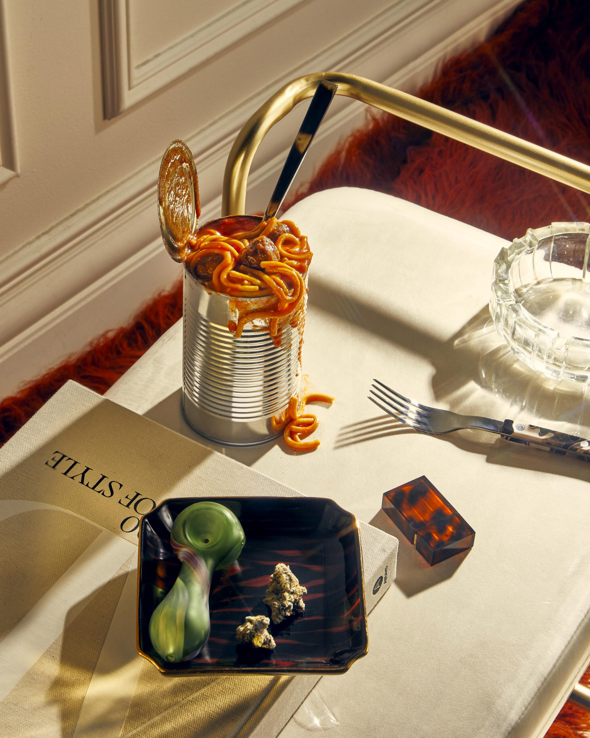 Spaghetti in a metal cup on a table beside menu and glassware