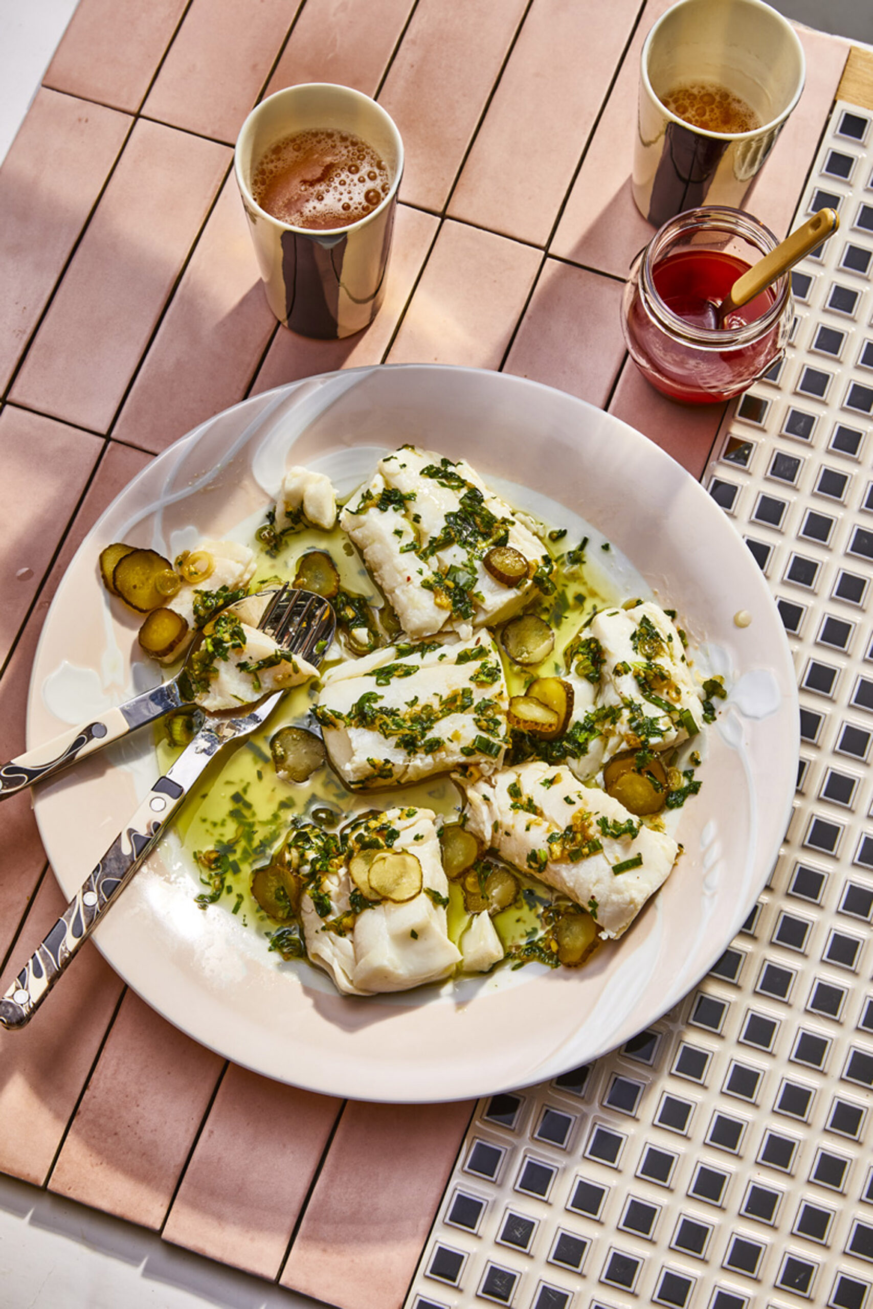 Overhead plate of gnocchi or ricotta pasta with herbs and pickles on an outdoor table