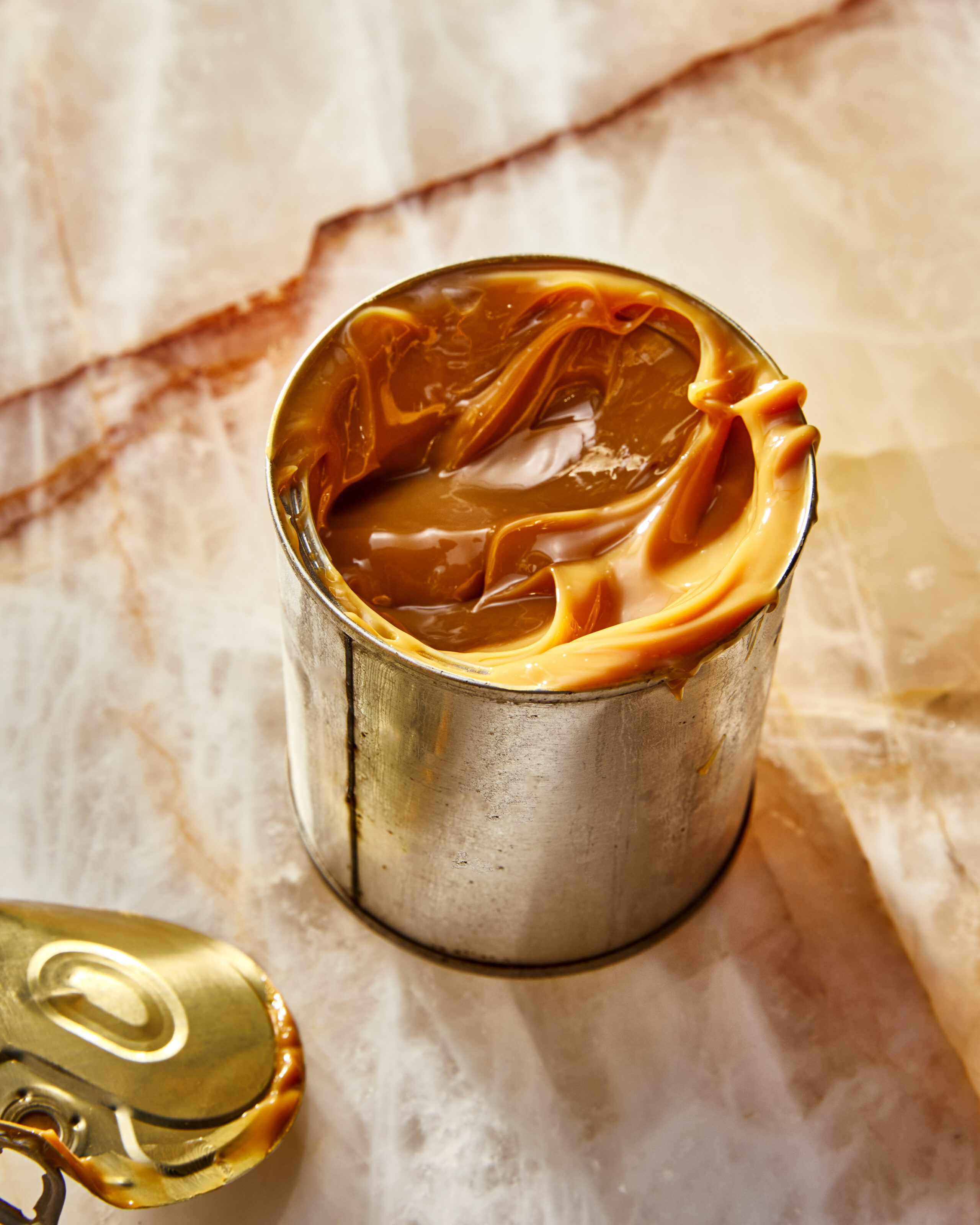 Metal tin filled with caramel or dulce de leche, close-up food photography