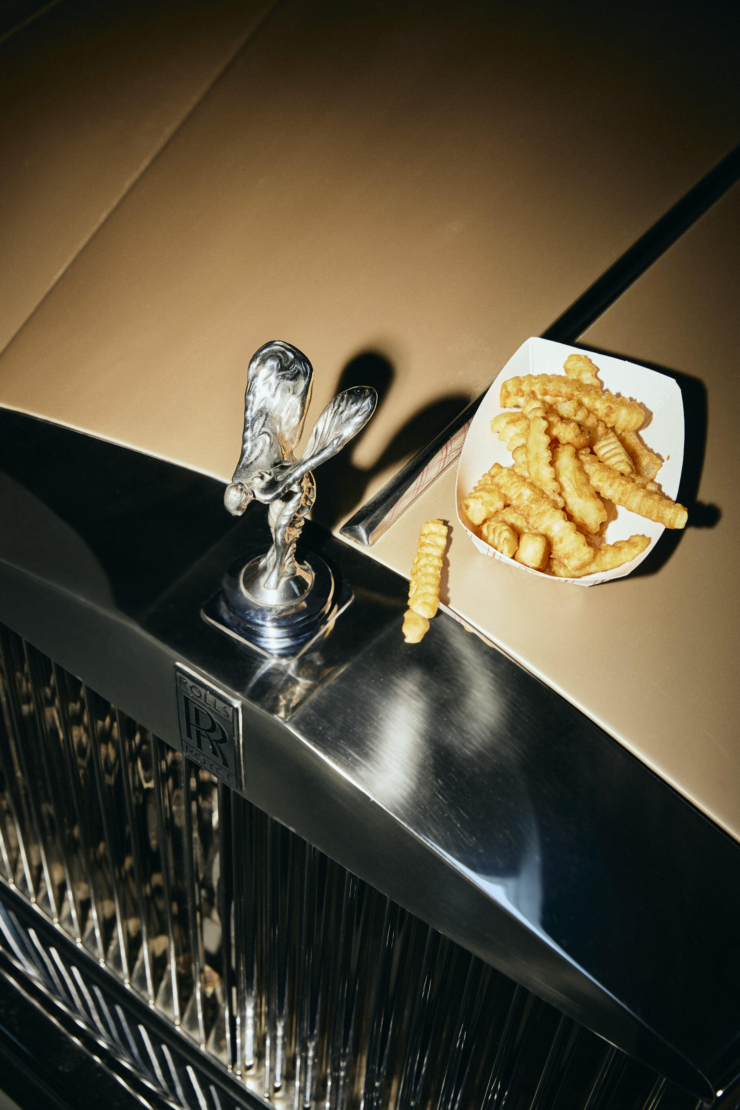 Basket of fries on a counter beside polished chrome bar fixtures
