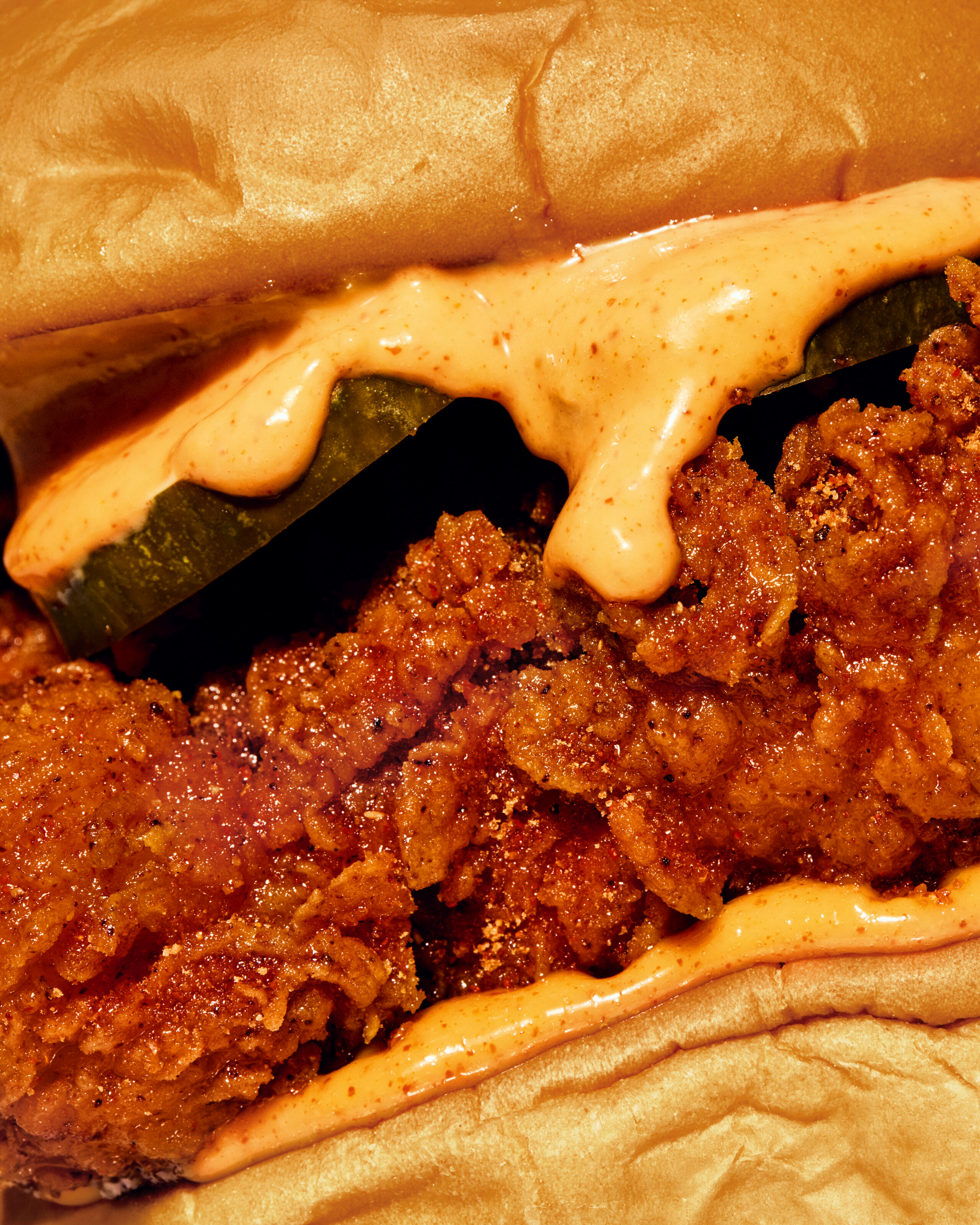 Close-up of crispy fried chicken sandwich with spicy sauce and soft bun