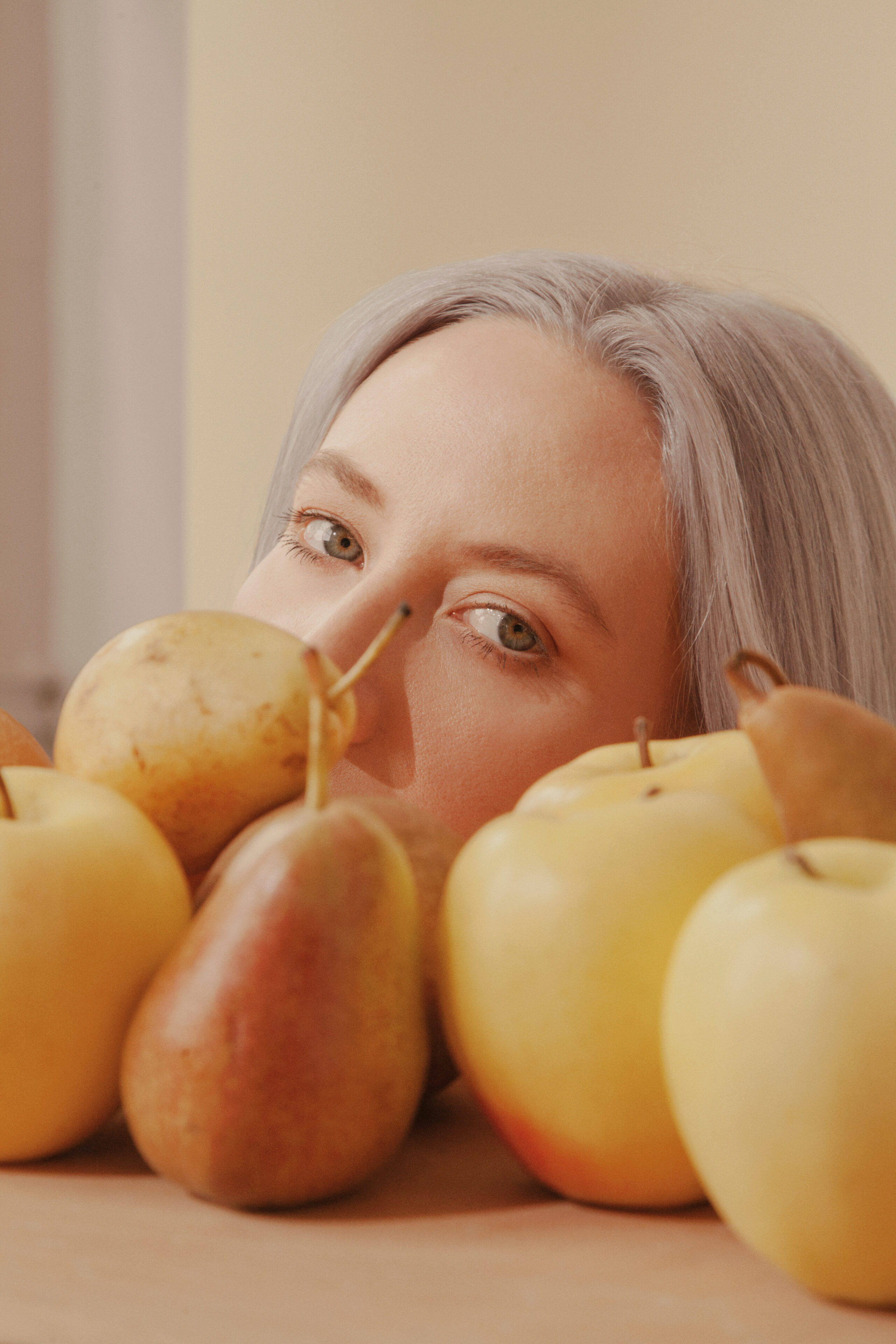 Close-up portrait partially framed by fruit in the foreground