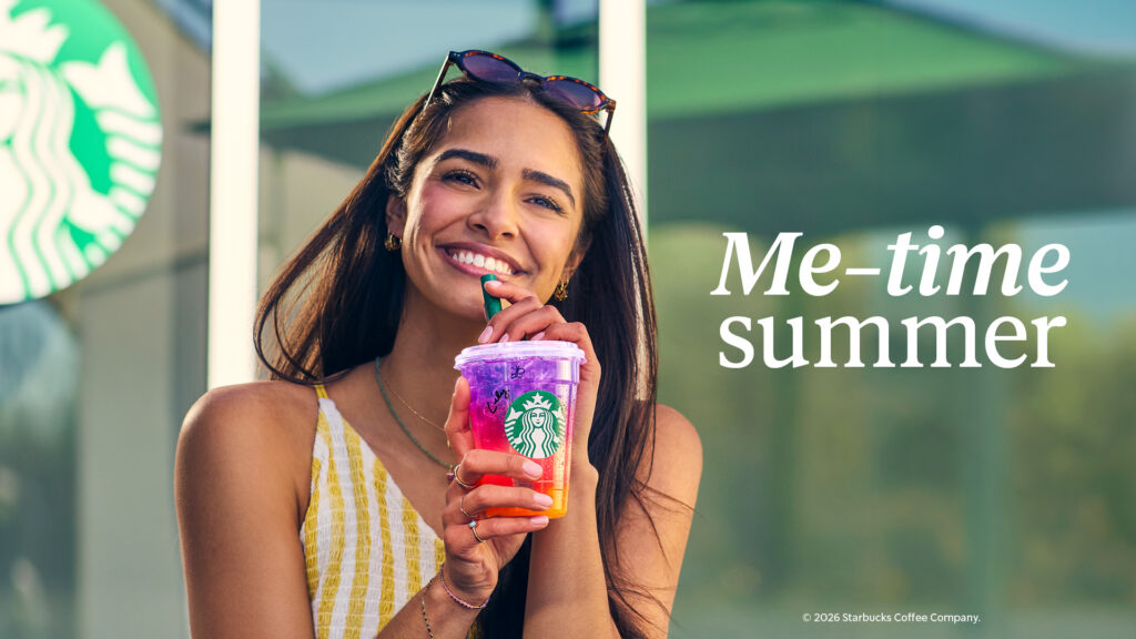 Smiling woman holding a colourful Starbucks summer drink outside a café with “Me-time summer” campaign copy.