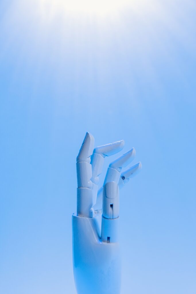 White robotic hand reaching upward against a soft blue background.